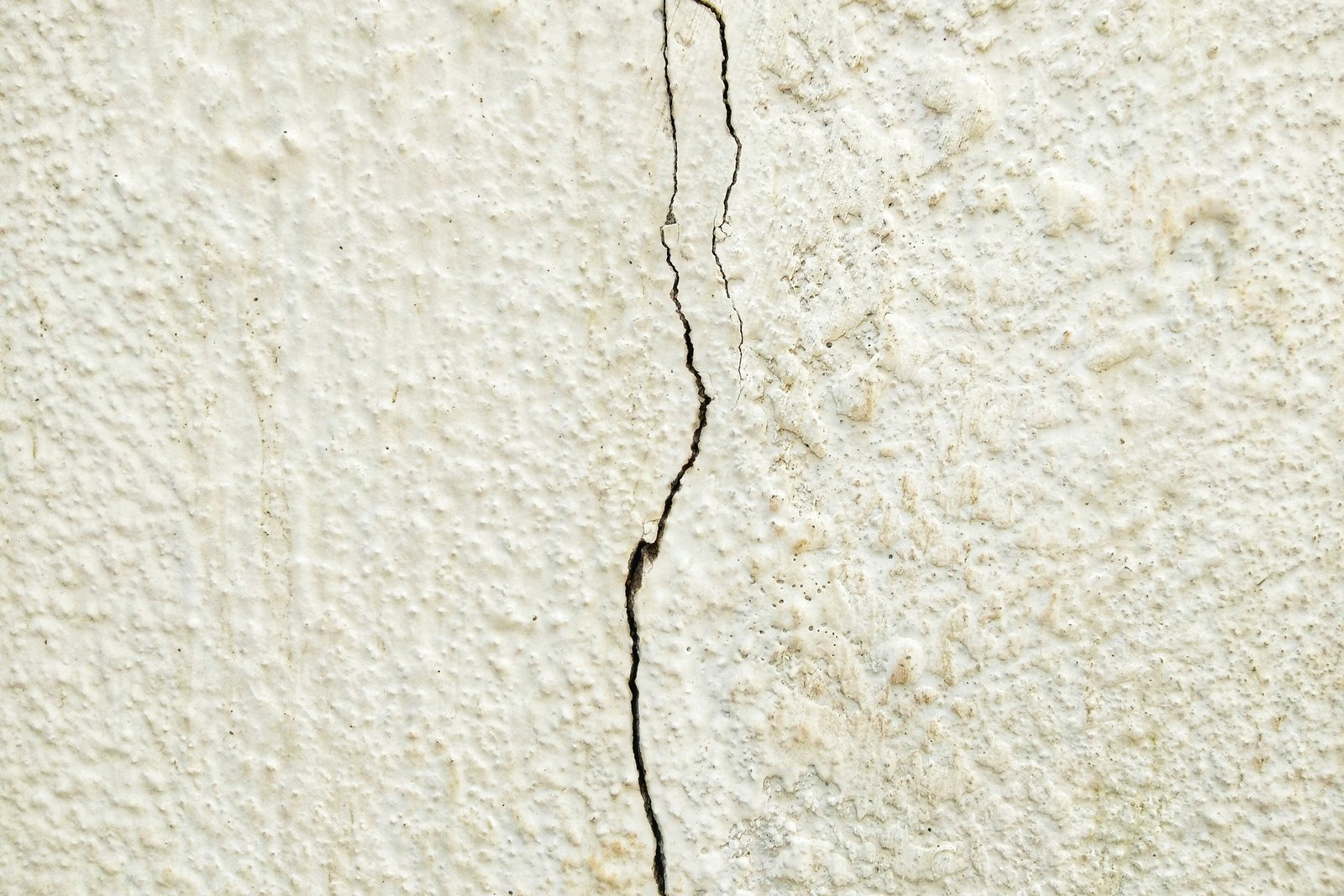 Teilweise abgeplatzter Putz an einer Innenwand mit sichtbaren Fehlstellen