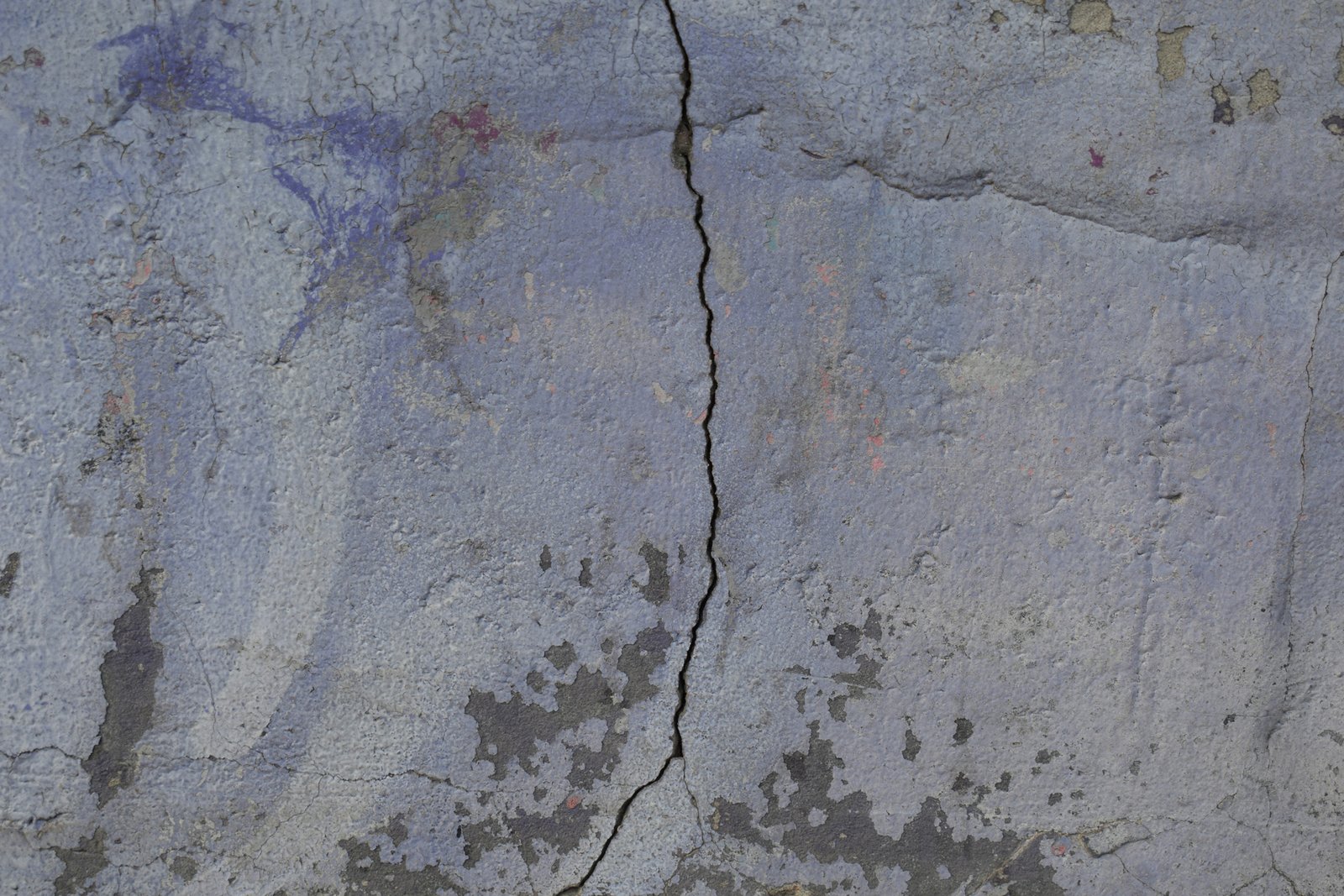 Innenwand mit bröckelndem Putz und sichtbaren kleinen Fehlstellen