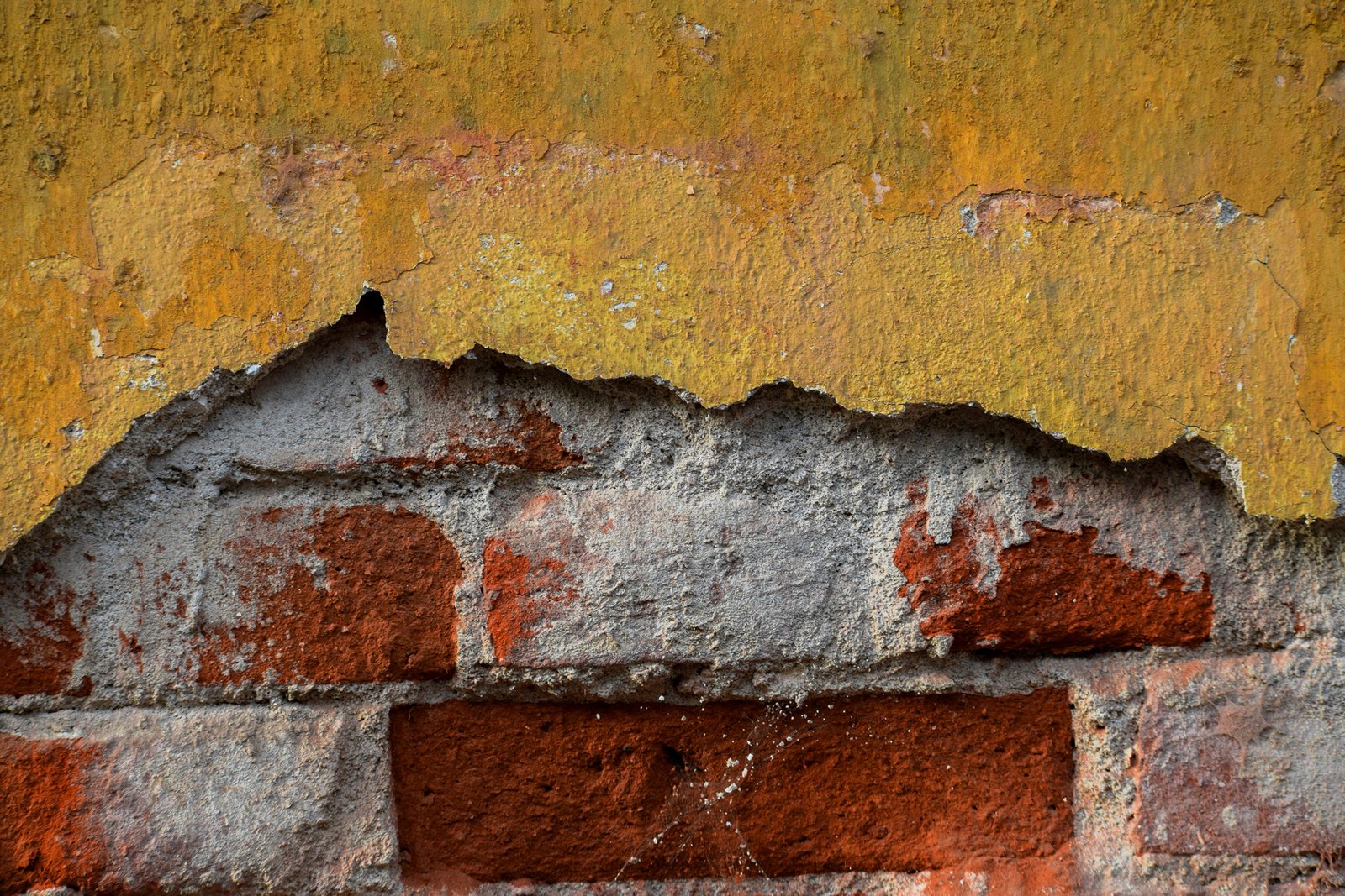 Außenwand mit abgeplatztem Putz und rauer Oberfläche