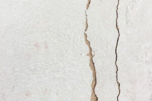 Abgeplatzter Putz an einer Innenwand mit sichtbarem Untergrund