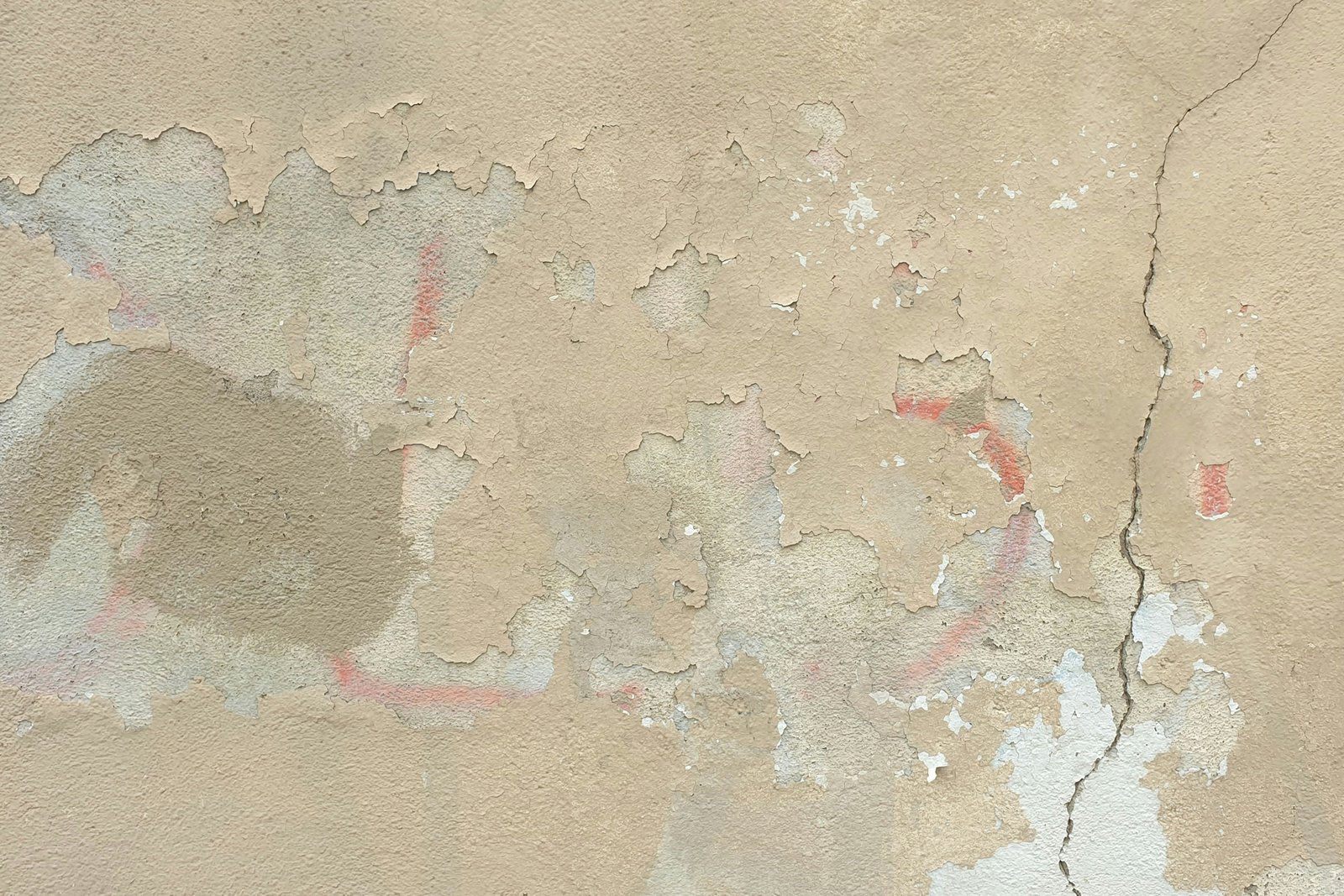 Hand mit Glättkelle beim Glattziehen einer verputzten Wand