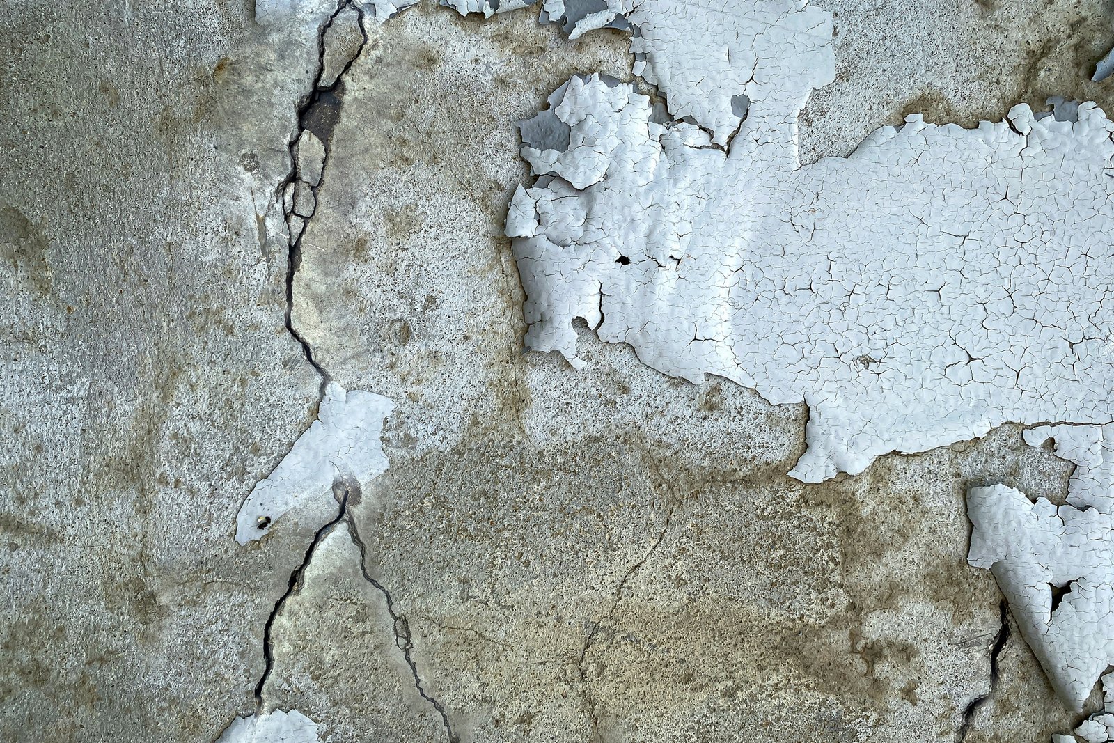 Wand mit sandender Putzoberfläche und feinem Putzstaub darunter