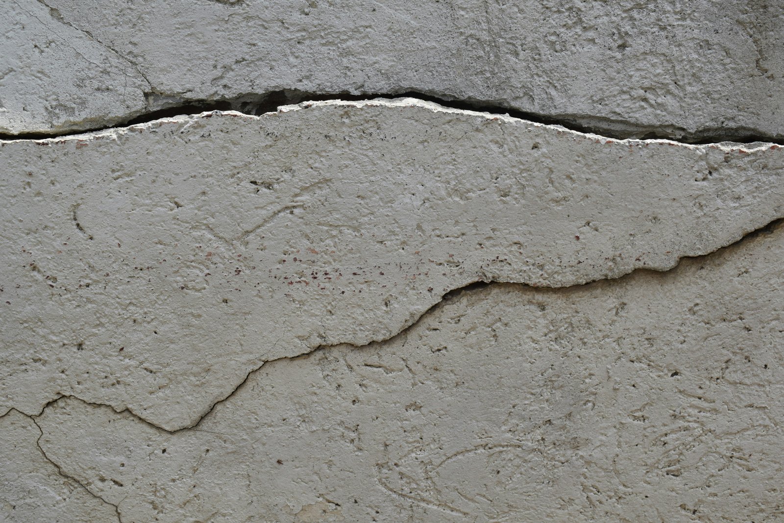 Wand mit geöffnetem Putzriss während der Reparatur mit Spachtel