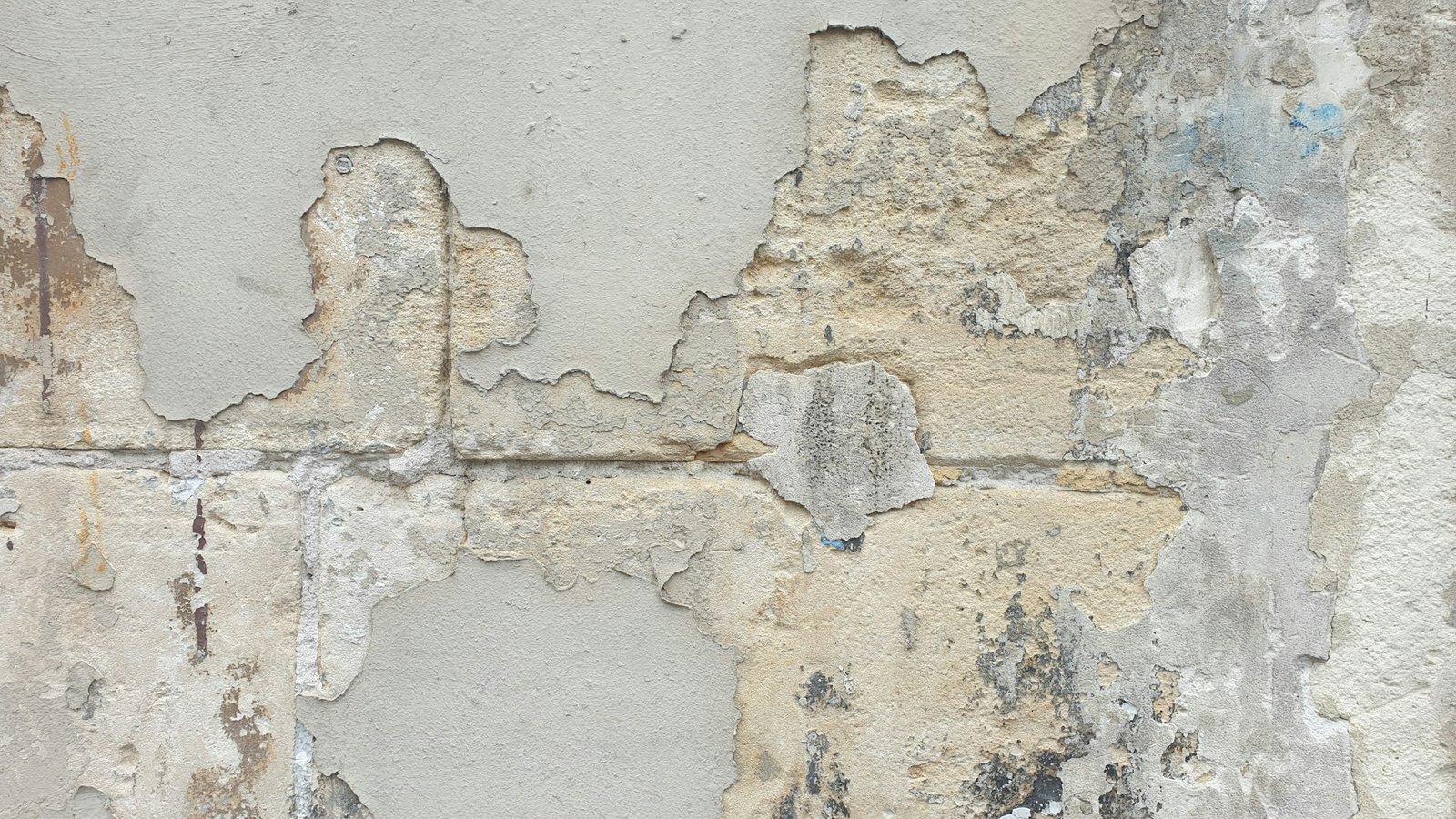 Abplatzende Farbe auf Putzwand